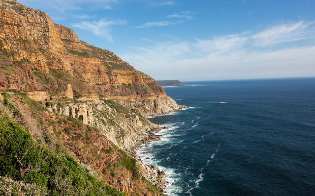 Auto op de kronkelende kustweg Chapman's Peak Drive boven de oceaan bij Kaapstad