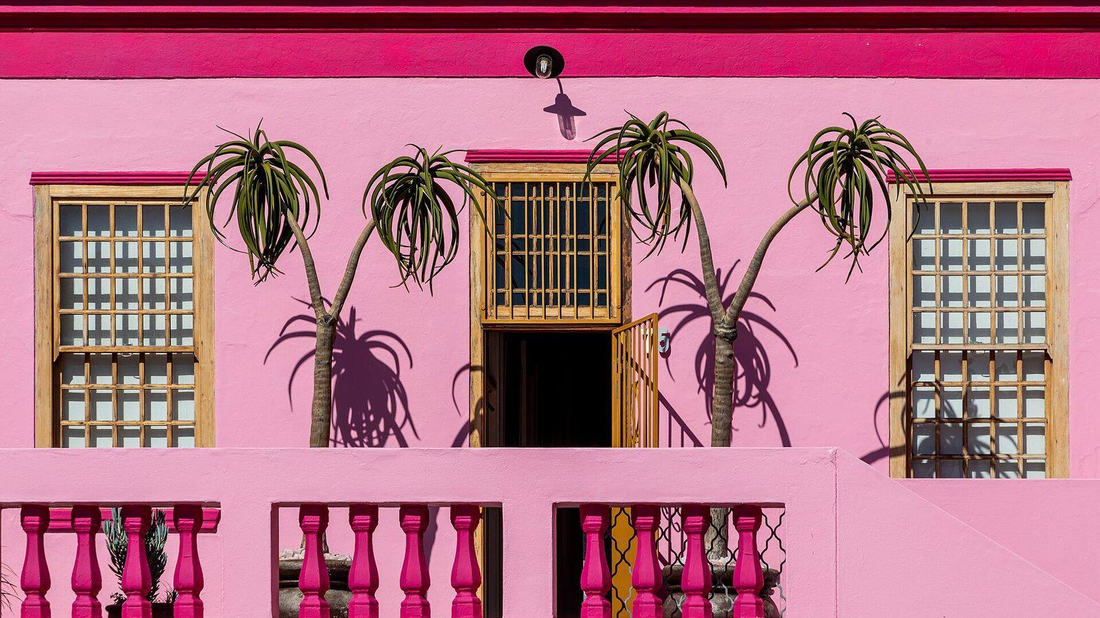 Felgekleurde huizen in een steile straat van de Bo-Kaap met de Tafelberg erachter