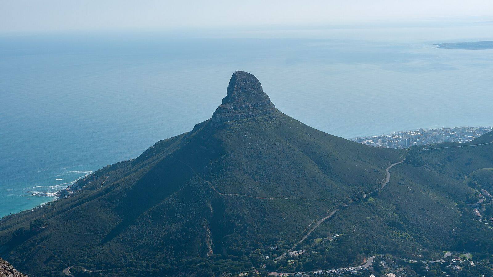 De spitse top van Lion's Head boven Kaapstad met de Atlantische Oceaan op de achtergrond