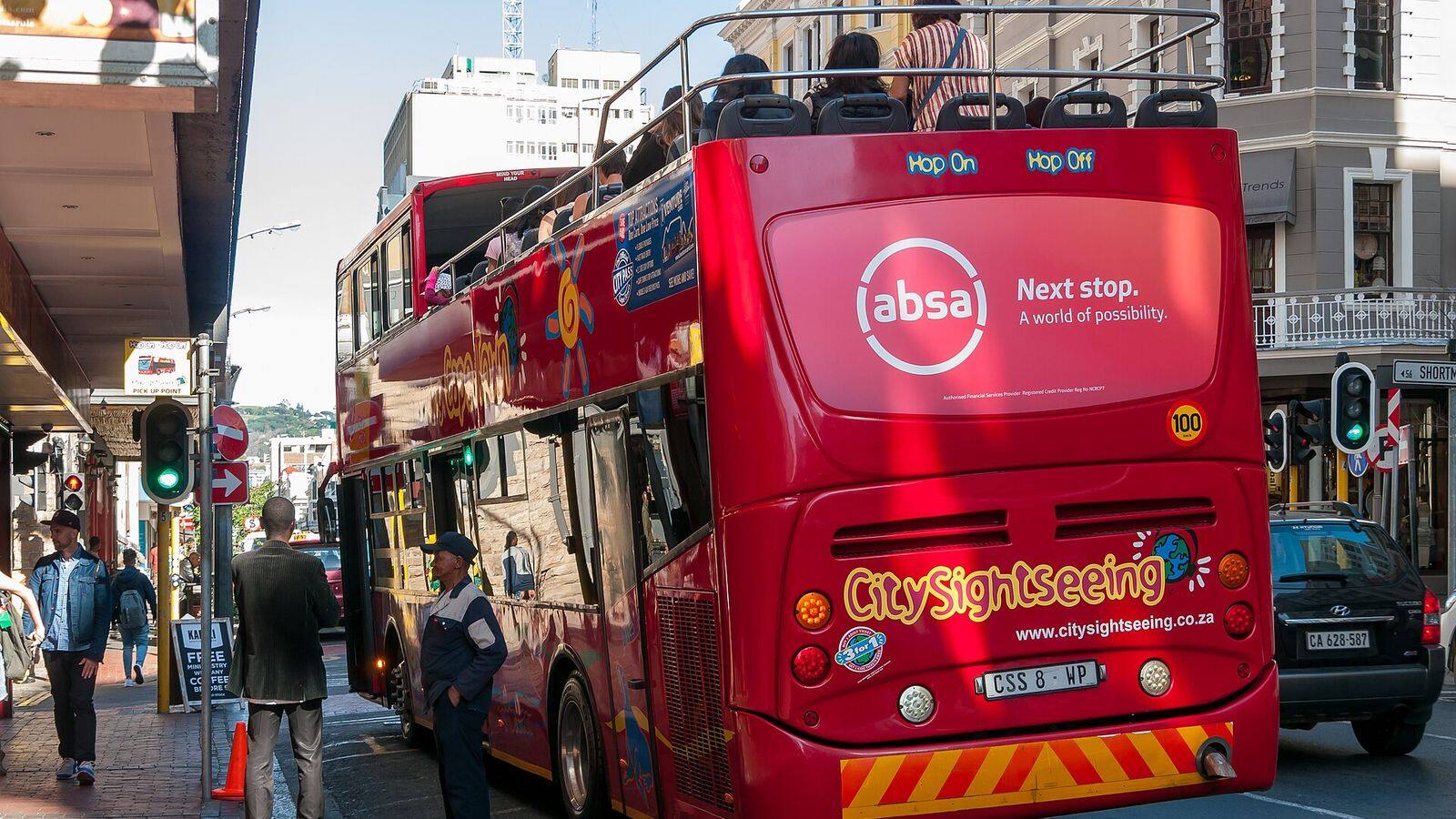 Rode hop-on-hop-off-sightseeingbus rijdt langs de kust van Kaapstad