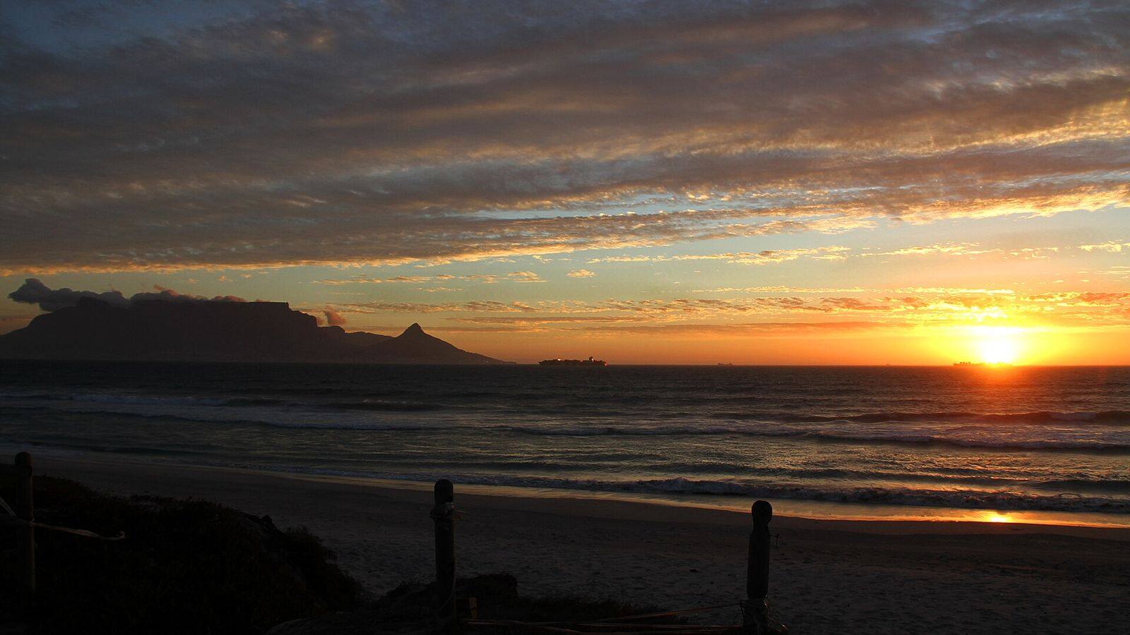 De Tafelberg in roze avondlicht gezien vanaf het strand van Bloubergstrand
